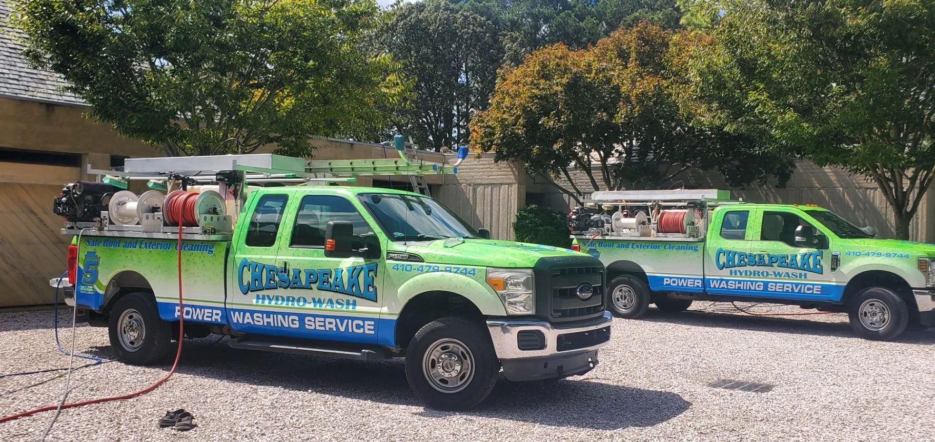 Two Chesapeake Hydro-Wash trucks ready for exterior cleaning work at a commercial property