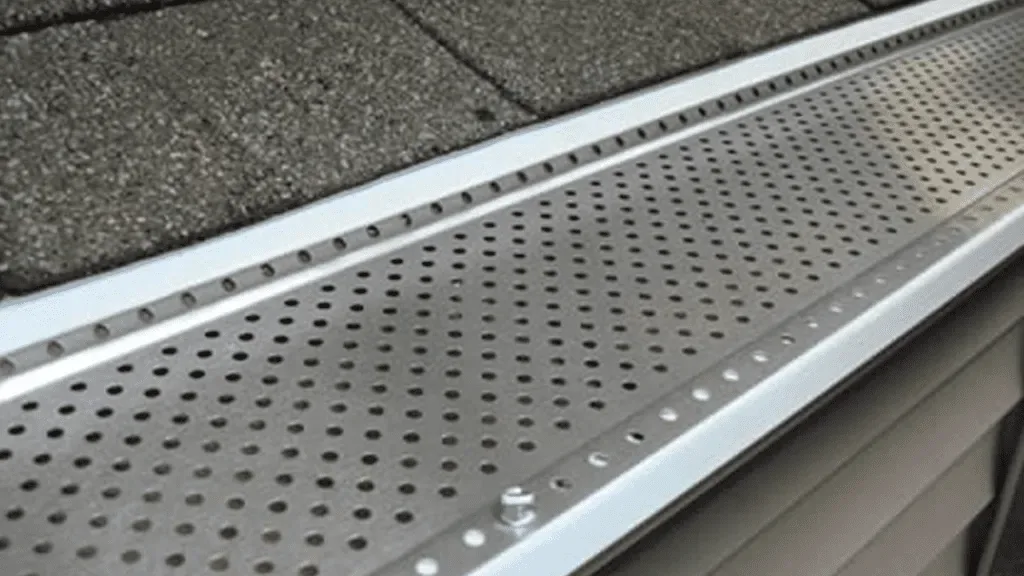 Perforated gutter guard installed along a roofline